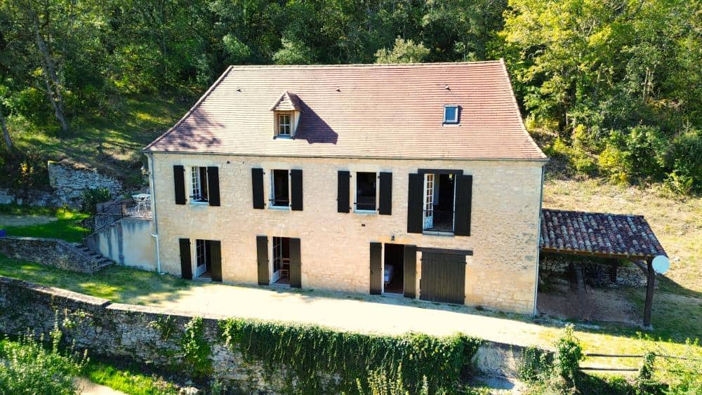 Schönes Landhaus mit historischen Mauern und schwarzen Fensterläden in La Combe de la Dame.