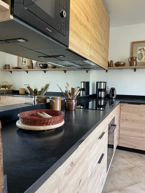 Hochwertige Küchendesign mit Holz und schwarzen Oberflächen, perfekte Ausstattung für modernem Kochbereich.