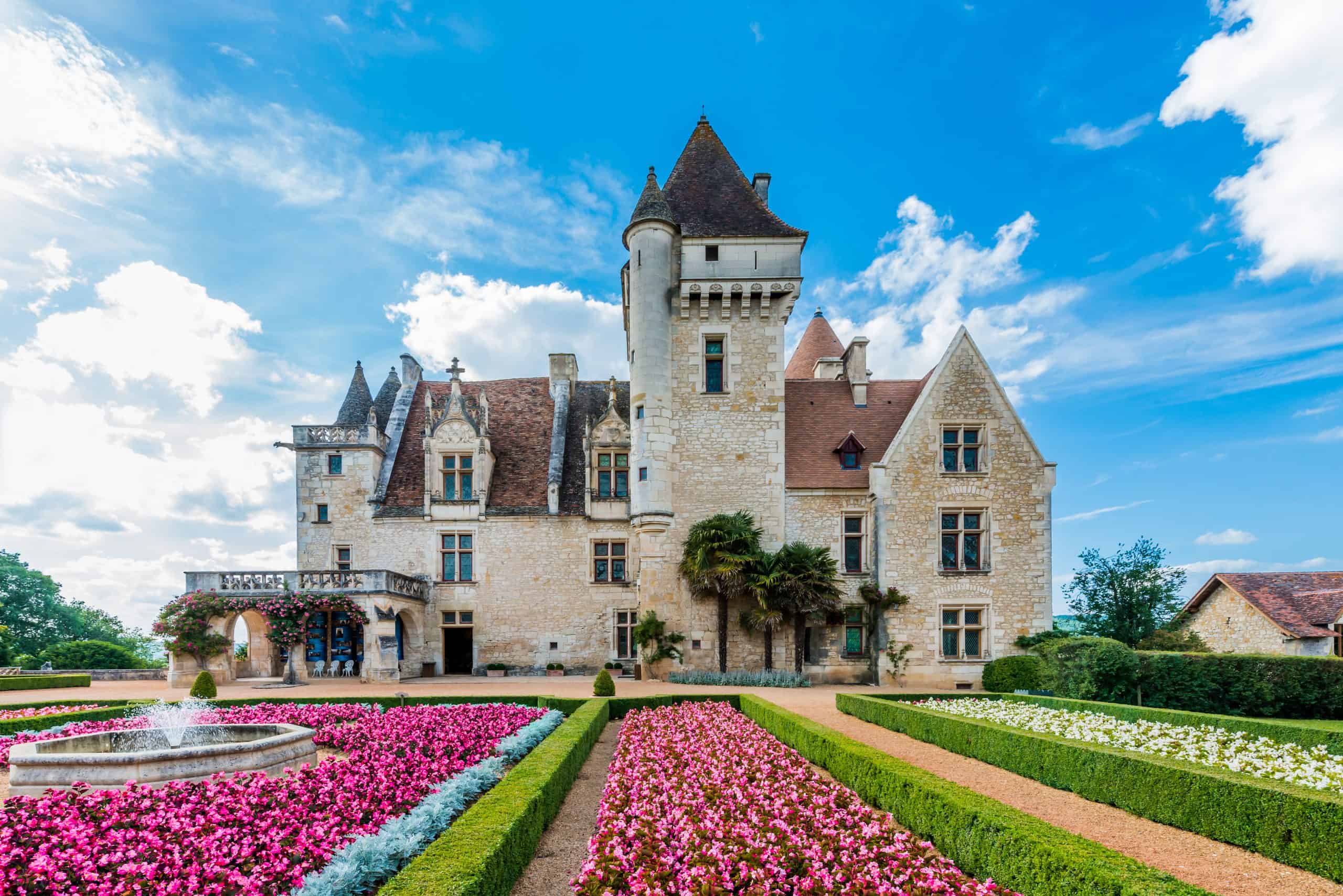 Historisches Château La Combe de la Dame inmitten gepflegter Blumen- und Parkanlagen, perfektes Reiseziel.